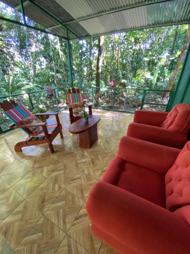 福尔图纳Grettel´s House Apartments, La Fortuna de San Carlos的客厅配有红色的沙发和椅子