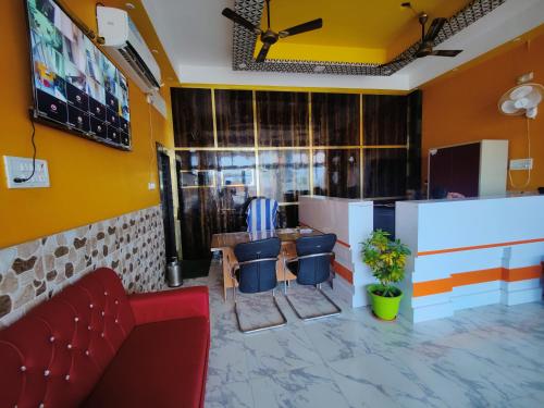 巴特那Hotel Shivaay Inn的一间设有红色沙发和椅子的等候室