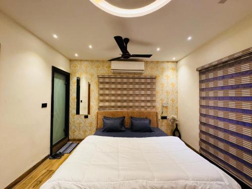 印多尔Home Escape Luxe 2BHK Penthouse Near LIG Square的一间卧室配有一张床和吊扇