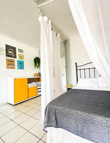 安格拉杜斯雷斯Studio com vista para o mar & Estacionamento Gratuito的卧室配有黑色和白色的床和窗帘