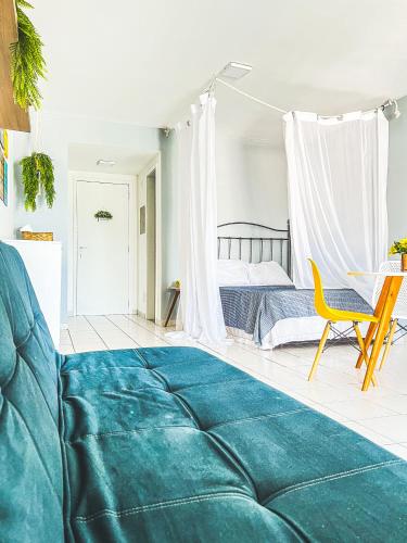 安格拉杜斯雷斯Studio com vista para o mar & Estacionamento Gratuito的一间卧室配有一张床和一张黄色椅子