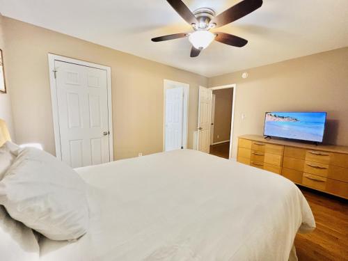 罗利Cozy 4 bedroom Cottage by Duke Raleigh Hospital的卧室配有白色的床和吊扇