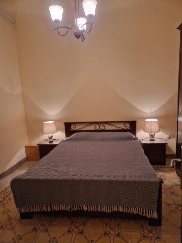 Għajn il-KbiraSir Patrick's rooms & hostel的一间卧室配有一张床,两台桌子上放着两盏灯
