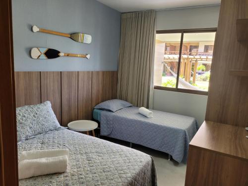 伊塔齐米林Village Beira Mar Itacimirim Boulevard Bahia的酒店客房设有两张床和窗户。