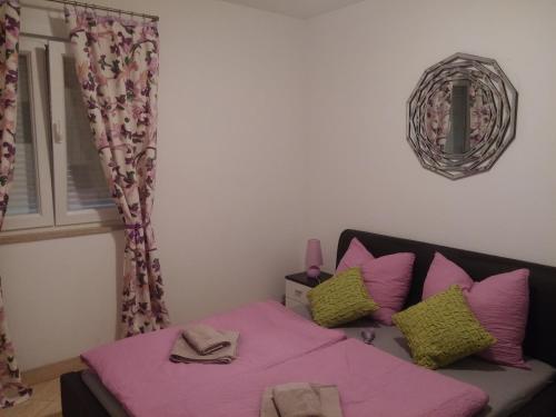 克罗诺维察Hostel **Casa del Sole**的一间卧室配有一张带粉色床单和枕头的床。