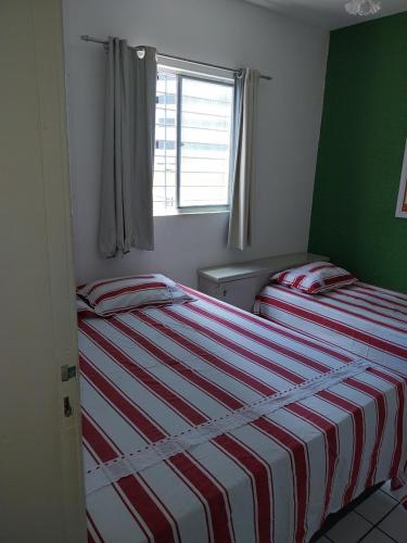 累西腓Hostel da Socorro的卧室设有两张床,拥有绿色的墙壁和窗户。