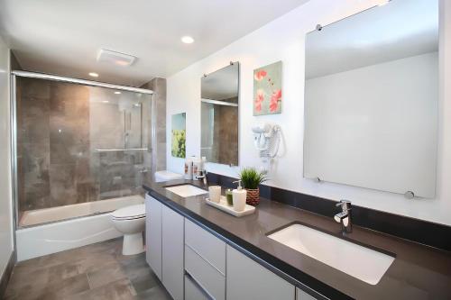 洛杉矶Los Angeles Premium Suites with Free Parking的浴室配有2个盥洗盆、卫生间和淋浴。