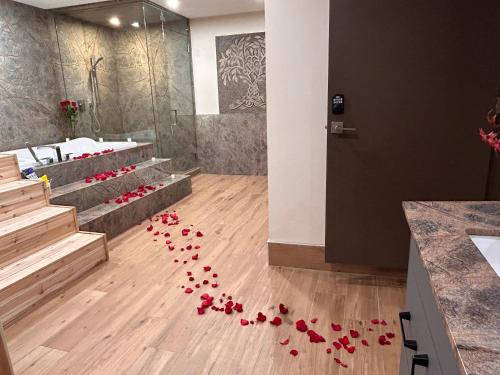 坎莫尔Luxury suite with Sauna and Spa Bath - Elkside Hideout B&B的浴室地板上一束红玫瑰