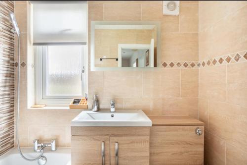 汉密尔顿Captivating 2 bedroom home with jacuzzi and conservatory的一间带水槽和镜子的浴室