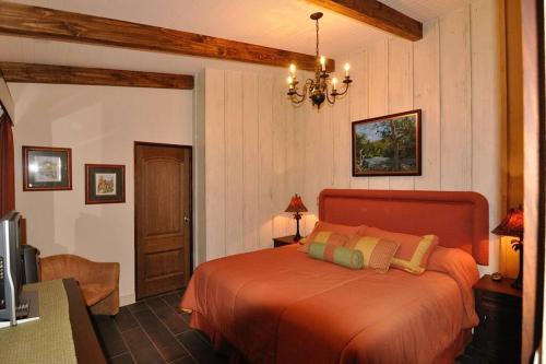 Cabin at Los Titos Coffee Farm的一间位于客房内的带橙色床的卧室