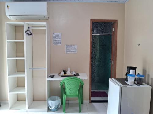 马瑙斯Edward Suíte Manaus 03的一间小厨房,内设一张绿色椅子