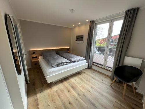 于斯德Dünen Lodge 3的一间卧室设有一张床和一个大窗户