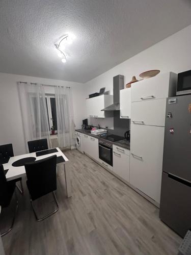 康斯坦茨Wohnen am Wasser - Privatzimmer - Sharing Apartment的厨房配有白色家电和桌椅