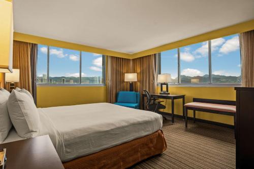 檀香山Best Western The Plaza Hotel - Free Breakfast的酒店客房设有一张床、一张书桌和窗户。