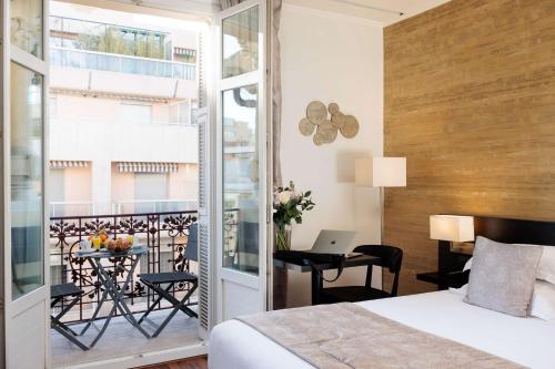 尼斯尼斯马塞纳贝斯特韦斯特酒店的一间卧室配有一张床,阳台配有书桌