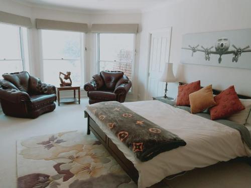 HeathcoteDowning Estate Homestead的一间卧室配有一张大床和两把椅子