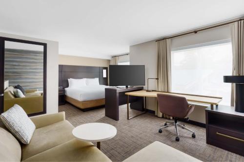 哈姆登Residence Inn by Marriott New Haven Hamden的酒店客房配有一张床、一张沙发和一张书桌。