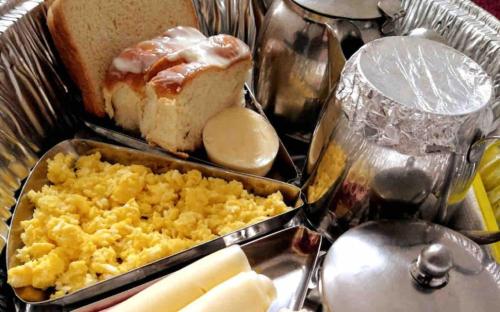瓜鲁雅Suite Guarujá的桌上的鸡蛋和面包托盘