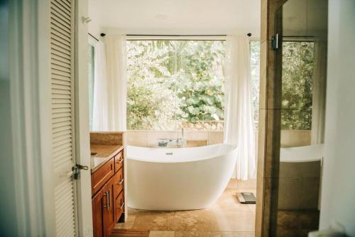 HauulaBeach Front/Free Breakfast/Hawaiian Retreat/Luxury的带浴缸的浴室和窗户