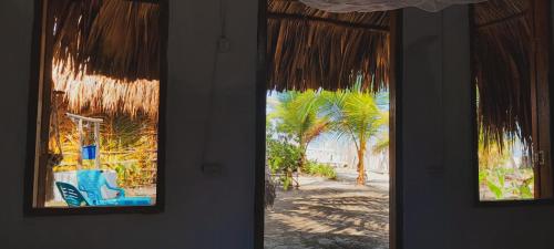 圣贝尔纳多德尔比恩托Sonar del Viento的两扇窗户享有棕榈树海滩的景致