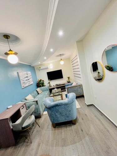 雅温得The Jumeirah Guest Home的客厅配有蓝色的家具和平面电视。
