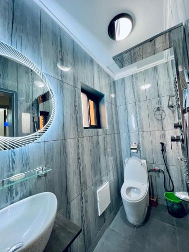 雅温得The Jumeirah Guest Home的一间带水槽、卫生间和镜子的浴室