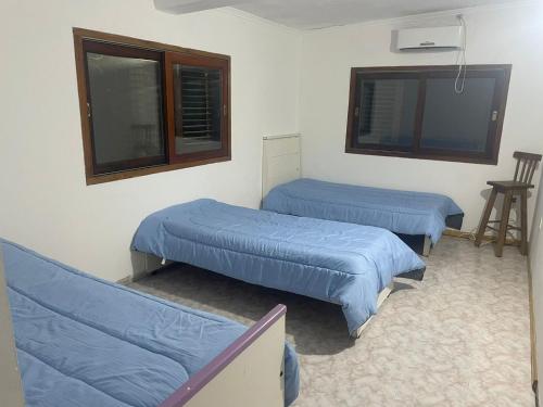 蓬塔因迪奥casa de campo的配有蓝色床单的客房内的两张床