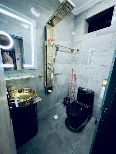 雅温得The Jumeirah Guest Home的浴室设有黑色的卫生间和水槽。