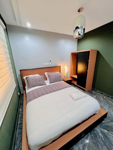雅温得The Jumeirah Guest Home的一间卧室配有一张大床和电视
