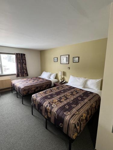 MinnedosaMinnedosa Inn的酒店客房设有两张床和窗户。