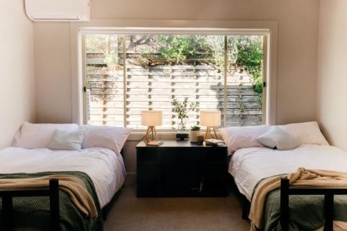索伦托Sorrento Lodge的带窗户的客房内的两张床