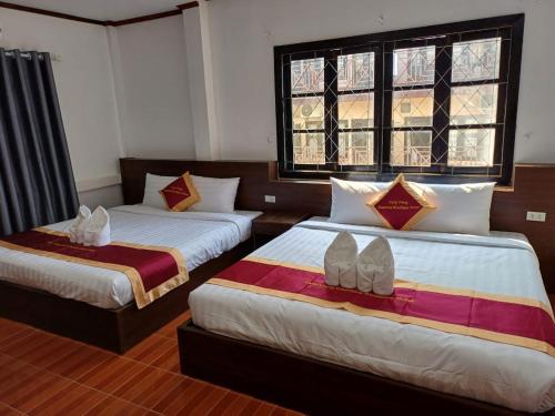 万荣VangVieng Charming Boutique Hotel的一间卧室配有两张床,并备有鞋子