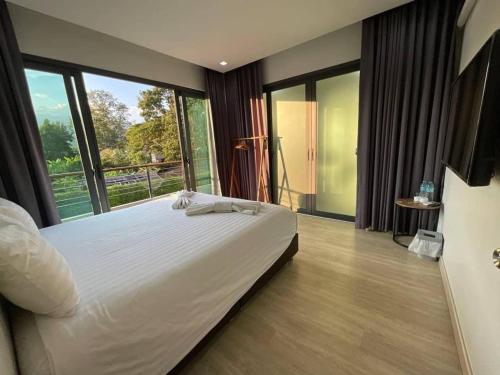 清迈65 hostel chiangmai的一间卧室设有一张大床和大窗户