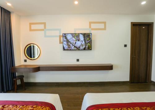 归仁Gia Kiên Hotel的客房设有两张床、一张桌子和镜子