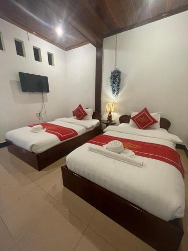 琅勃拉邦Ouis NamKhan Place House的一间卧室配有两张床和一台平面电视