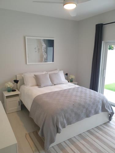 西湾Modern 1 bedroom walking distance to the beach!的白色的卧室设有一张大床和一个窗户