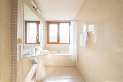春川乐土江村度假村 的浴室配有盥洗盆和浴缸。