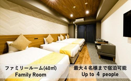 大阪Takuto Hotel Osaka Shinsaibashi的酒店客房设有三张床和电视。
