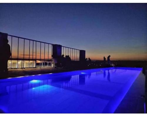 内罗毕Luxe Oasis的大楼前方设有蓝色灯光的大型游泳池