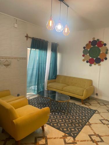 MamoudzouChambre Mamoudzou的客厅配有两张黄色的沙发和玻璃桌