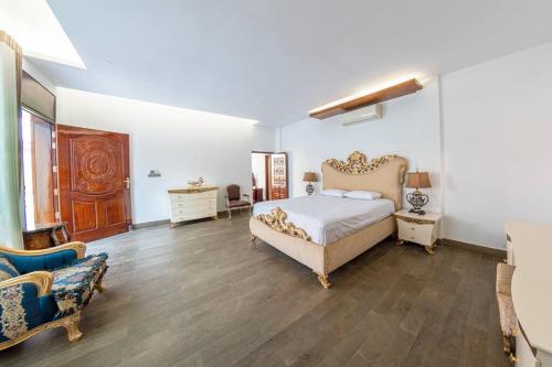 达卡Grand Villa Oasis的一间卧室配有一张特大号床和一张沙发