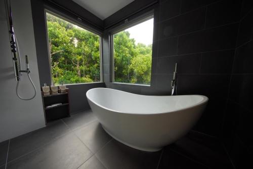 备濑Secret Pool villa Seji的带窗户的浴室内的白色大浴缸
