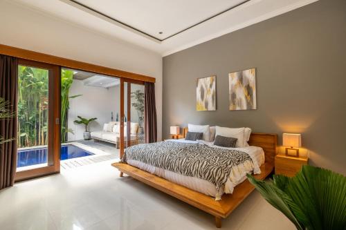 坎古Villa Royal Canggu - 3 minutes to FINNS Beach club!的一间卧室设有一张床和一个滑动玻璃门