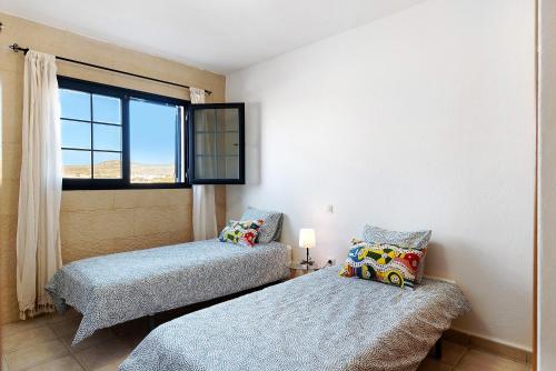 塞博河畔卡莱塔Apartamento Cabo的带窗户的客房内的两张床