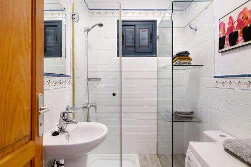 塞博河畔卡莱塔Apartamento Cabo的一间带水槽和玻璃淋浴的浴室