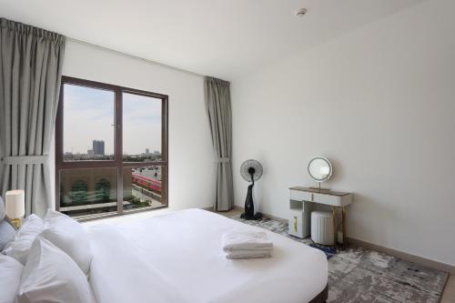 迪拜Livbnb Suites - Madinat Jumeirah Living - Cozy 2 Bedroom near Burj Al Arab的卧室设有白色的床和大窗户