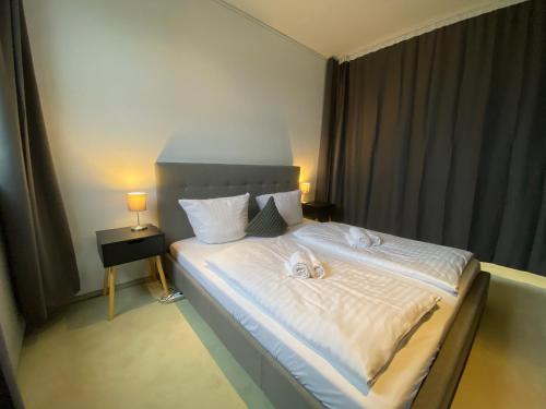 门兴格拉德巴赫Exklusives Penthouse 232QM Whirlpool 28min bis Düsseldorf Messe的一间卧室配有一张床,上面有两条毛巾
