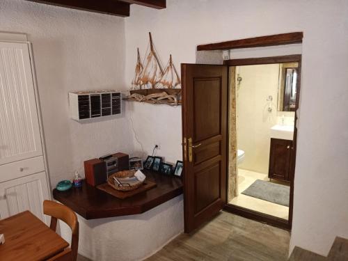 莫奈姆瓦夏Kissamitakis Guesthouse的浴室设有门和带微波炉的桌子。