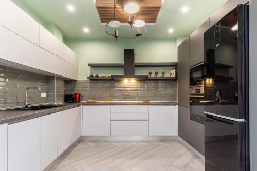 塞萨洛尼基#Amazonia Apt by halu! Apartments的厨房配有白色橱柜和不锈钢用具