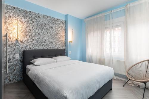 塞萨洛尼基#Amazonia Apt by halu! Apartments的一间卧室配有一张带蓝色墙壁的大床